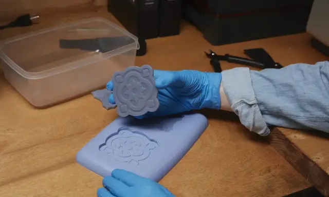 Manos enguantadas muestran un molde de silicona recién hecho, demostrando cómo hacer moldes de silicona para crear piezas decorativas.