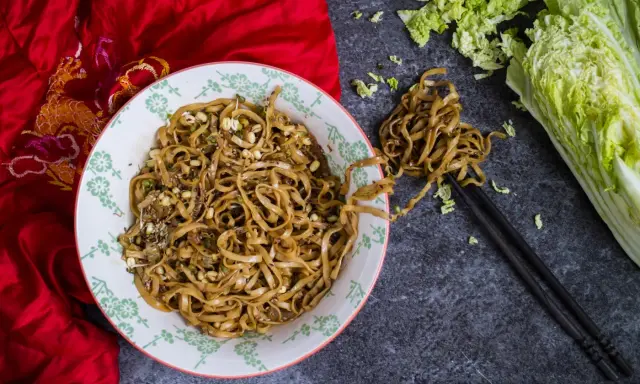 En skål med nudlar, böngroddar och sesamfrön, redo att avnjutas. Ett enkelt nudlar recept för en snabb måltid.