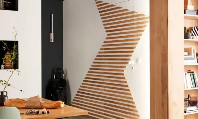 Une porte transformée en œuvre d'art avec des lattes de bois, une idée de diy deco murale moderne et épurée.
