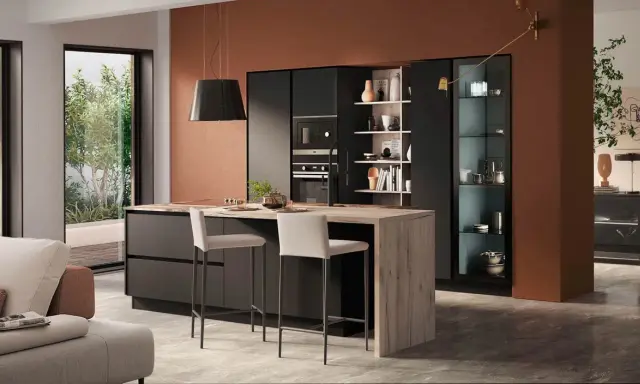 Elegante zona giorno open space con cucina moderna, isola centrale in legno e soggiorno accogliente.