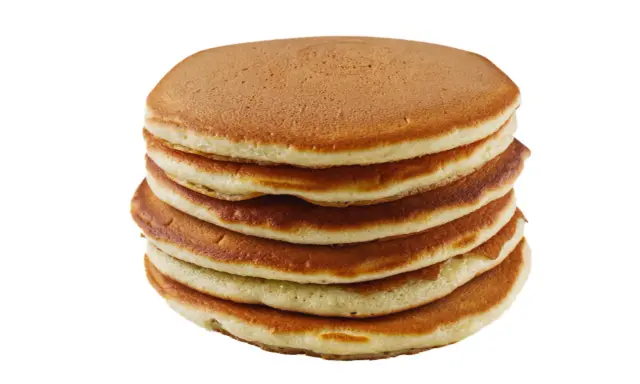 Pile de pancakes dorés faits maison avec de la farine complète, prêts à être dégustés.