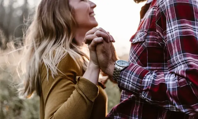 Glückliches Paar hält Händchen. Sie strahlt, er trägt kariertes Hemd. Vielleicht ein Zeichen für den Vaterkomplex bei Frauen?