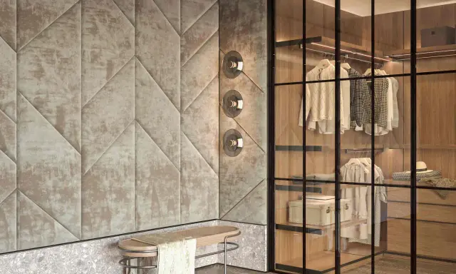 Ingresso con boiserie moderne in tessuto trapuntato geometrico, panca in legno e vimini, e cabina armadio a vista con illuminazione integrata.