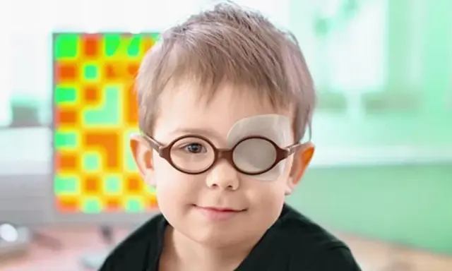 Niño con gafas y parche en el ojo, tratando su ojo vago. Detrás, una pantalla con un patrón de colores.