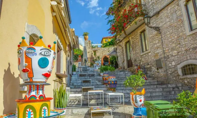 Colorate ceramiche artistiche adornano una scalinata a Taormina, un luogo incantevole per famiglie con bambini.