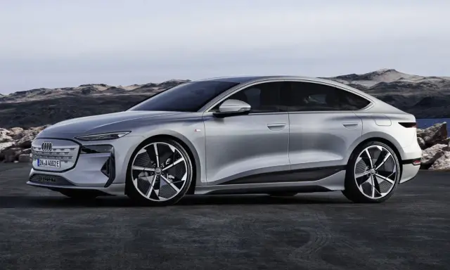 Silberner Audi A4 e-tron, ein elegantes Elektroauto, steht vor einer felsigen Küstenlandschaft.