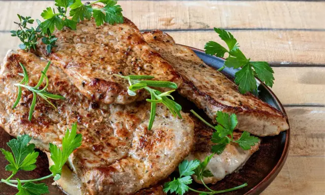 Soczysty schab z airfryer, idealnie przypieczony, podany z gałązkami rozmarynu i natki pietruszki. Pyszne i zdrowe danie.
