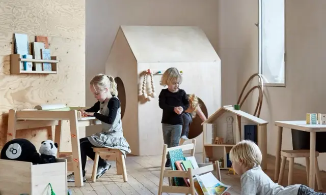 Dzieci bawią się i uczą przy stoliku sensorycznym IKEA FLISAT w pokoju zabaw.