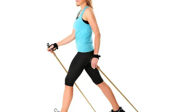 Kobieta z kijami do nordic walking. Dowiedz się, jak dobrać kije do nordic walking, by trening był efektywny i bezpieczny.