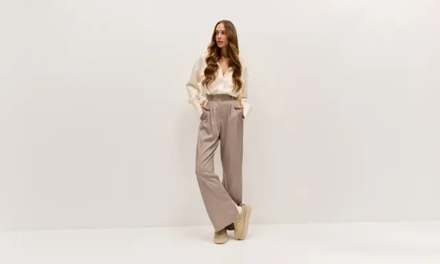 Elegancka kobieta w luźnych spodniach i koszuli. Lyocell: wady i zalety tego materiału w modzie.