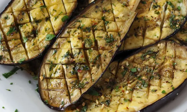 Gegrilltes Gericht mit Aubergine, gewürzt mit Kräutern und Knoblauch.