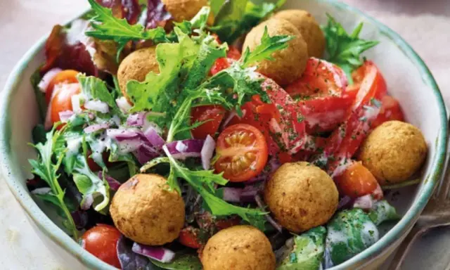 Bunter Salat mit Tomaten, Zwiebeln und Falafelbällchen. Ein schnelles gesundes Essen, das gut aussieht und schmeckt.