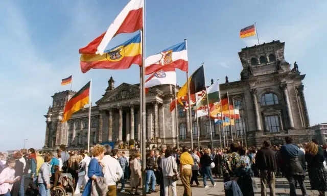 Många flaggor vajar framför Riksdagshuset i Berlin, en symbol för nationell stolthet och nationalismens betydelse.