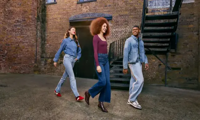 Three friends walk down an alleyway, showcasing how denim is breathable and stylish in various cuts and washes.