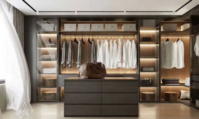 Un dressing moderne et organisé, parfait pour savoir comment ranger son dressing. Chemises blanches suspendues, tiroirs sombres et sacs en cuir.