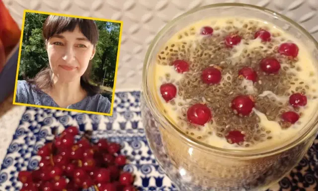 Kobieta uśmiecha się obok deseru z nasionami chia i porzeczkami. Nasiona chia – właściwości odchudzające w pysznej formie.
