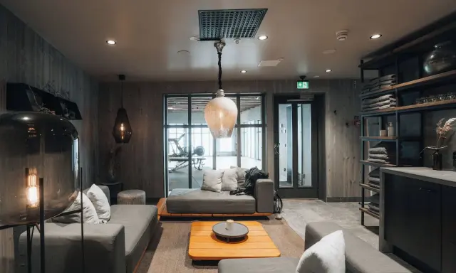 Mysig lounge med soffor och ett gym i bakgrunden på Niehku Mountain Villa.