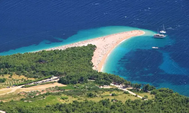 Zloty piasek i turkusowa woda na chorwackiej plaży. Idealne miejsce na bezpośrednie loty do Chorwacji.