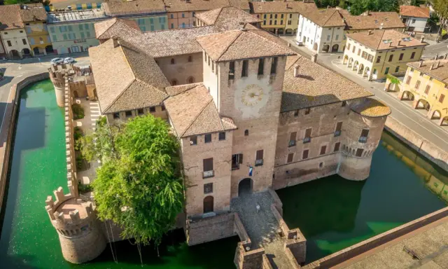 Castello di San Martino in Rio, uno dei tanti splendidi posti da visitare in Emilia Romagna, circondato da un fossato verde.