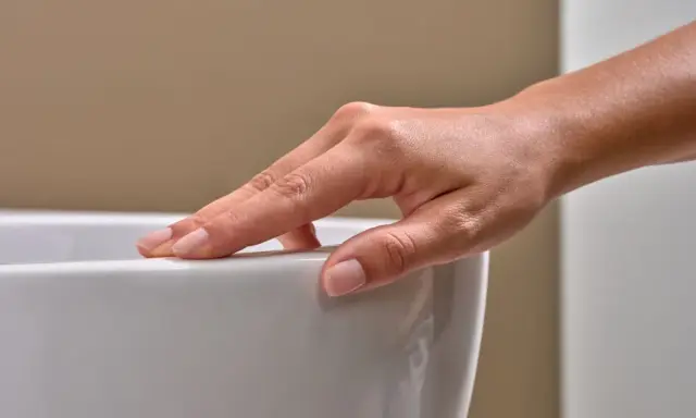 Eine Hand streicht über eine weiße Oberfläche. Mögliche Keratect Nachteile könnten hier eine Rolle spielen, wenn die Oberfläche empfindlich ist.