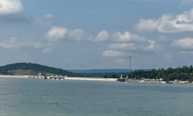 Widok na zaporę w Solinie, z widocznymi gondolami kolejki linowej i licznymi szlakami turystycznymi w tle.