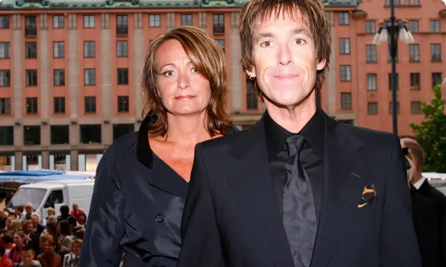 Gessle, ung och stilig, poserar med en kvinna framför en byggnad i Stockholm.