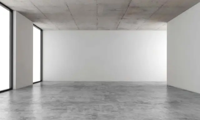 Espacio minimalista con paredes blancas, techo de hormigón y suelo de **cemento pulido** que refleja la luz.