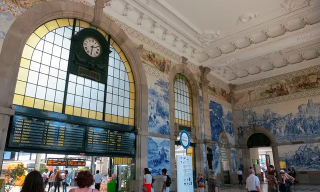 Der Bahnhof Porto mit seinen beeindruckenden Azulejo-Kacheln und einer großen Anzeigetafel.