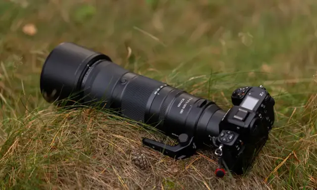 Profesjonalny aparat Nikon Z8 z obiektywem Nikkor 180-600mm leży na trawie. To co to jest aparat, to narzędzie do uwieczniania chwil.