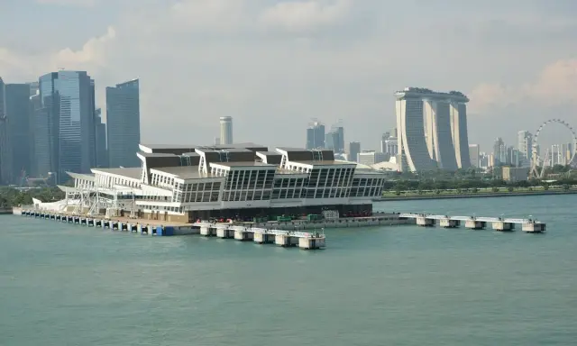 Moderno terminal crociere galleggiante nel **singapore porto**, con grattacieli iconici sullo sfondo.