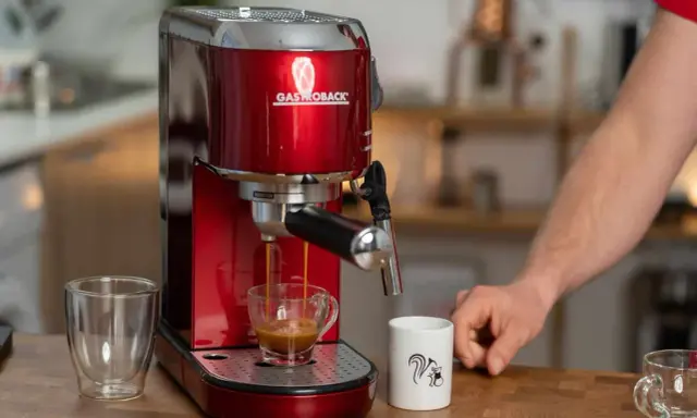 Rote Kaffeemaschine brüht Espresso mit Crema. Eine normale Kaffeemaschine für den perfekten Start in den Tag.