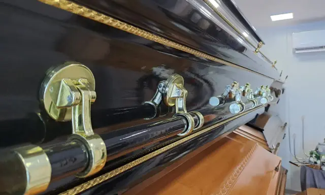 Elegancka, czarna trumna z ozdobnymi uchwytami. Warto pomyśleć, jak napisać ostatnie pożegnanie, gdy przyjdzie taki moment.