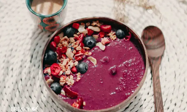 Fruchtige Acai-Bowl mit Blaubeeren, Granola und Beeren – perfekt, wenn du deine eigene Bowl selber machen möchtest. Dazu eine Tasse Kaffee.