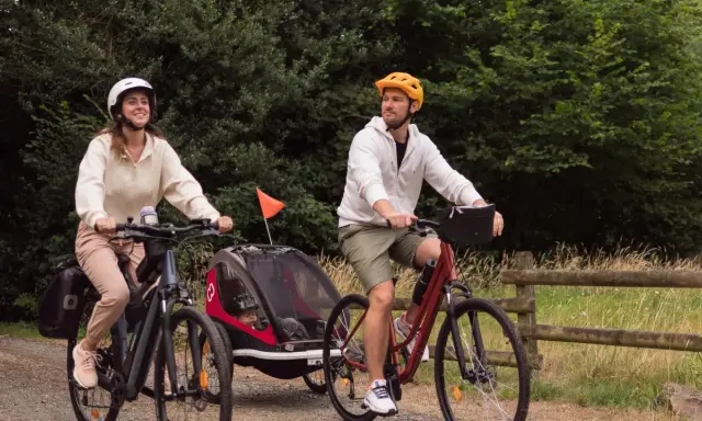 Para wycieczka rowerowa z dzieckiem w przyczepce. Zastanawiasz się, jakie buty na rower będą najlepsze? Oni wybrali wygodne sportowe obuwie.