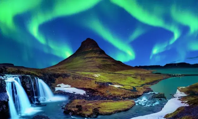 Islandia najpiękniejsze miejsca: góra Kirkjufell i wodospad pod tańczącą zorzą polarną.