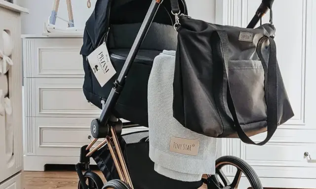 Stylowe wyposażenie wózka dla noworodka: czarna torba i miękki kocyk Tiny Star.