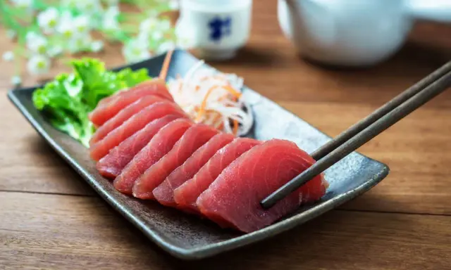 Väl förberedd tonfisk sashimi på en tallrik, redo att avnjutas med en god vin. En klassisk kombination för en lyxig måltid.
