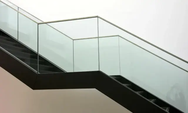 Escalera moderna con barandillas de cristal. ¿Cómo saber si un cristal es templado? La seguridad es clave.