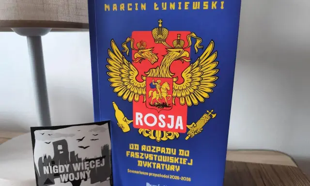 Książka "Rosja od rozpadu do faszystowskiej dyktatury" Marcina Łuniewskiego obok naklejki "Nigdy więcej wojny".