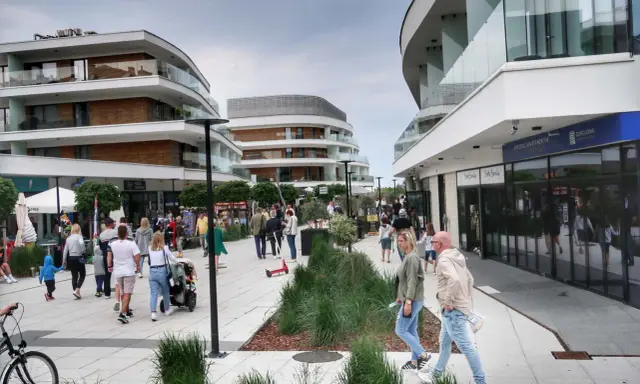 Spacerowicze cieszą się nowoczesną architekturą i sklepami na promenadzie w Świnoujściu. Atrakcje dla każdego!