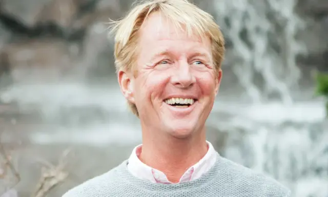Glad man med blont hår och ljus tröja, skrattar hjärtligt. En natthiko Lindeblad i sin bästa stund.