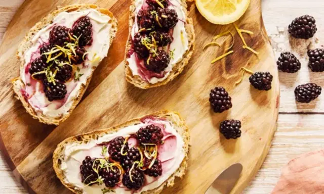 Tartines de pain grillé avec fromage frais, mûres et zeste de citron. Un encas healthy et gourmand, parfait pour un petit-déjeuner ou une pause.