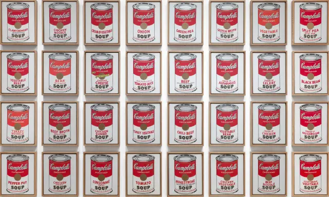 Andy Warhol's repetition art showcases a grid of Campbell's soup cans, each a unique flavor, creating a vibrant pop art statement.
