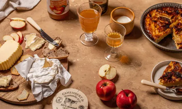 Un plateau gourmand avec camembert, pain, beurre, pommes et tarte aux pommes, une spécialité normandie.