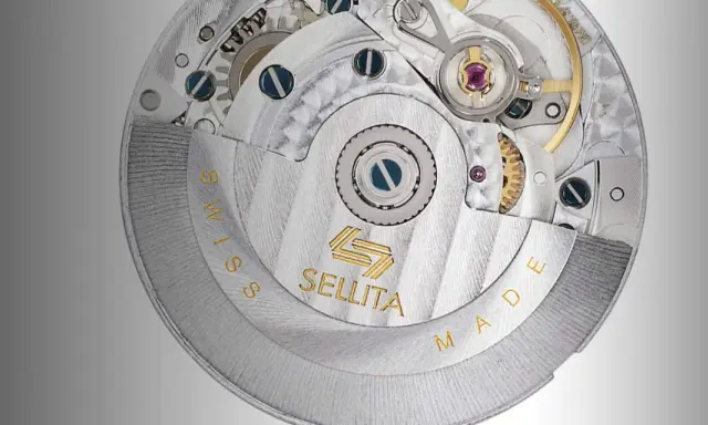 Dettaglio del movimento Sellita, con ingranaggi e finiture di precisione. La scritta "SWISS MADE" circonda il meccanismo.