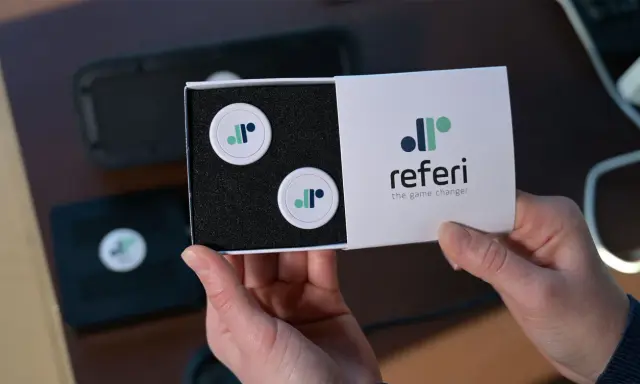 Scatola con due gettoni e logo "referi", un segnapunti online gratis per cambiare il gioco.