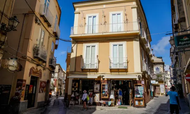 Un vicolo di Tropea con negozietti e palazzi color ocra, un'atmosfera che ricorda la porta vaticana.