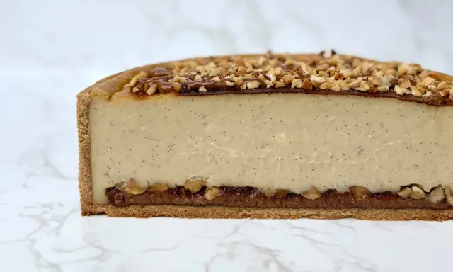 Tranche de flan praliné onctueux, garni de noisettes concassées et d'un coulis de caramel.