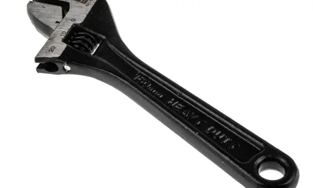 Llave inglesa negra, con marcas de medición en milímetros y la inscripción "HEAVY DUTY". Es una herramienta robusta, como el pie del rey.