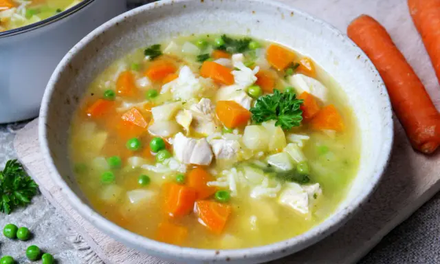 Herzhafte Hühnersuppe mit Reis, Karotten und Erbsen. Ein ideales Gericht für kalte Tage, das zu den besten Suppen Rezepten zählt.